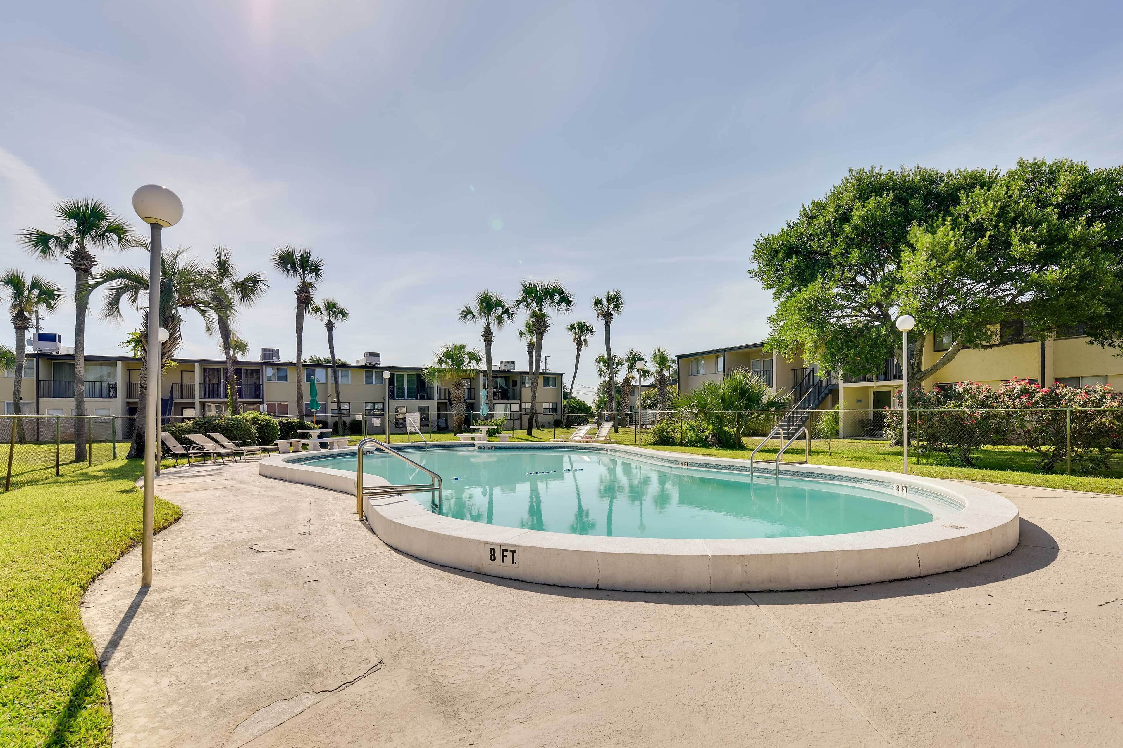 A swimming pool with a 8 ft diameter, surrounded by palm trees and a concrete deck.
