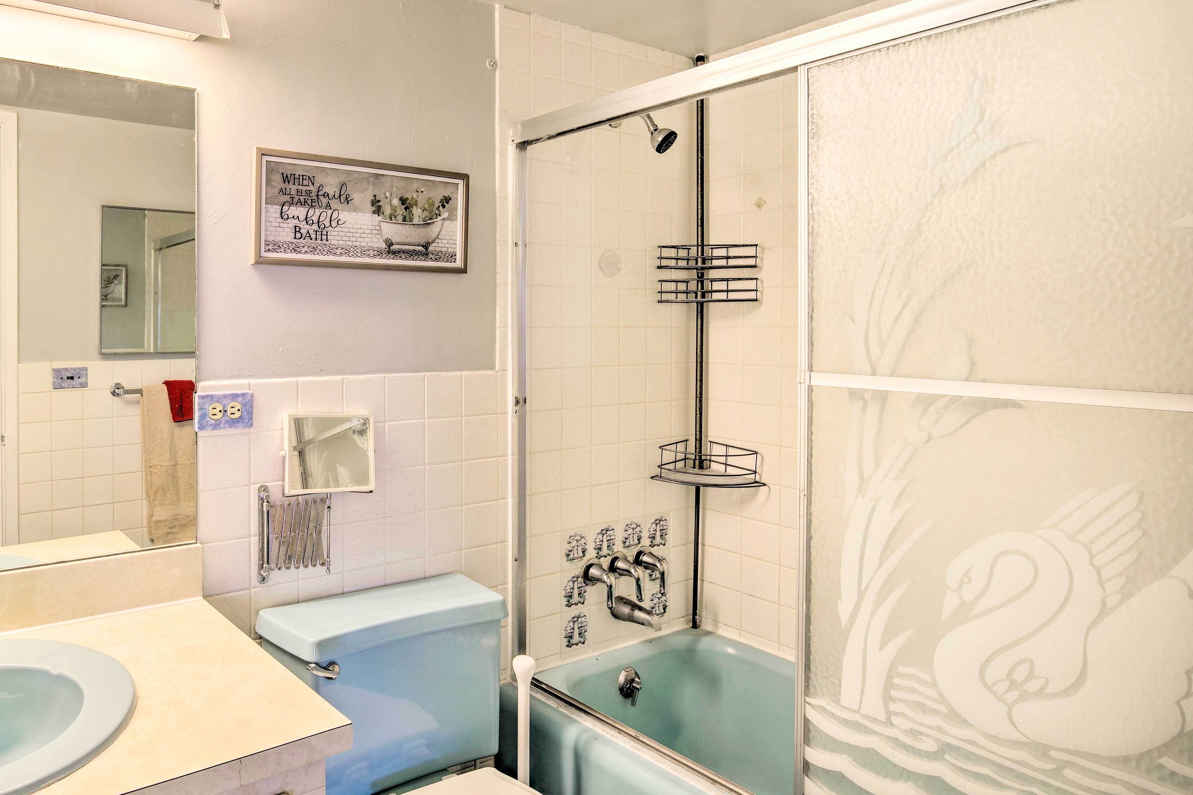 A bathroom with a bathtub, a shower, a toilet, a sink, and a mirror.