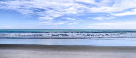 A beach with a clear sky and calm sea.