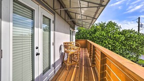 Une terrasse en bois avec une porte vitrée et un espace abrité.