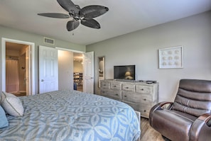 A bedroom with a bed, a ceiling fan, a dresser, a TV, and a reclining chair. - St Pete Condo w/ Heated Pool - 3 Miles to Beach! (St. Petersburg)