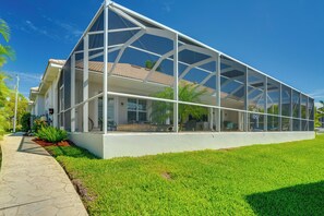 A modern house with a large glass extension, a paved driveway, and a well-maintained lawn. - 3 Mi to Downtown Cape Coral: Canal-front Villa (Cape Coral)