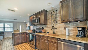 A modern kitchen with dark wood cabinets, granite countertops, and stainless steel appliances.