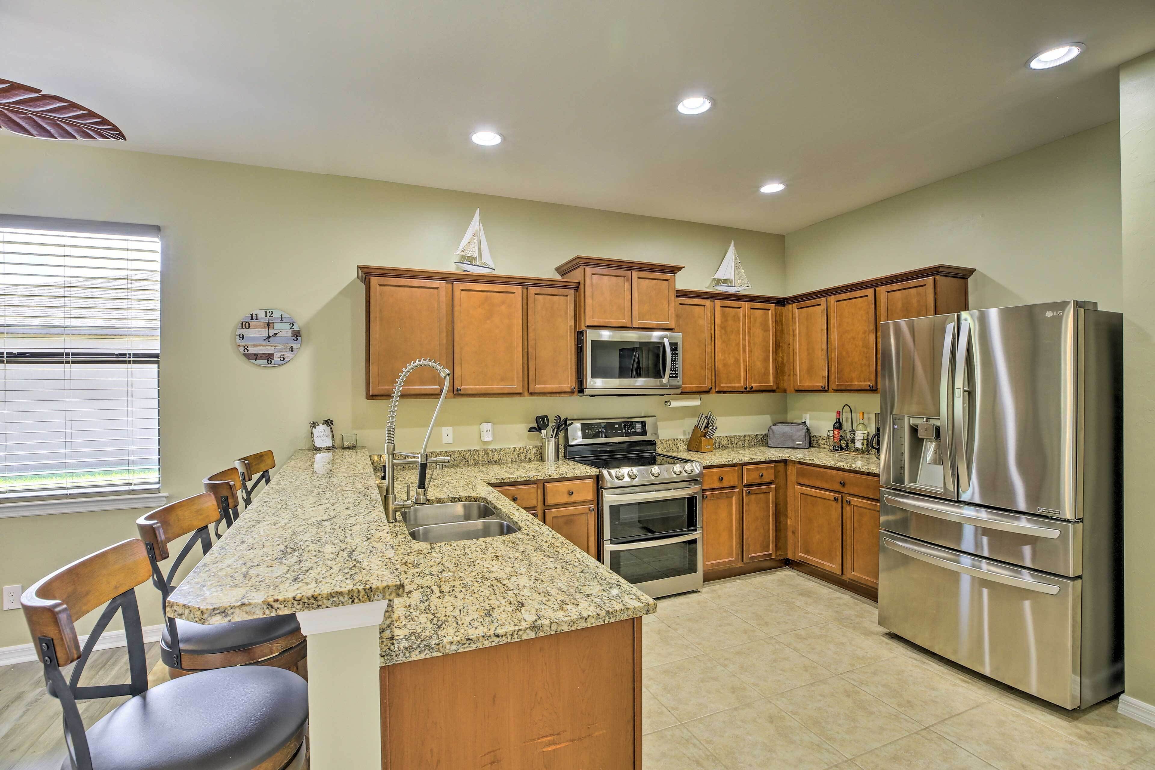A kitchen with wooden cabinets, stainless steel appliances, a granite countertop, and a built-in oven.