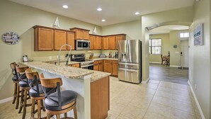 A spacious kitchen with wooden cabinets, stainless steel appliances, and a granite countertop. - Pool & Lanai: Centrally Located Cape Coral Home (Cape Coral)