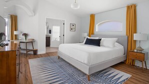 A modern bedroom with a large bed, bedside tables, a desk, and a bathroom visible through an open door. - Davenport Vacation Home w/ Pool, Spa & Game Room! (Davenport)