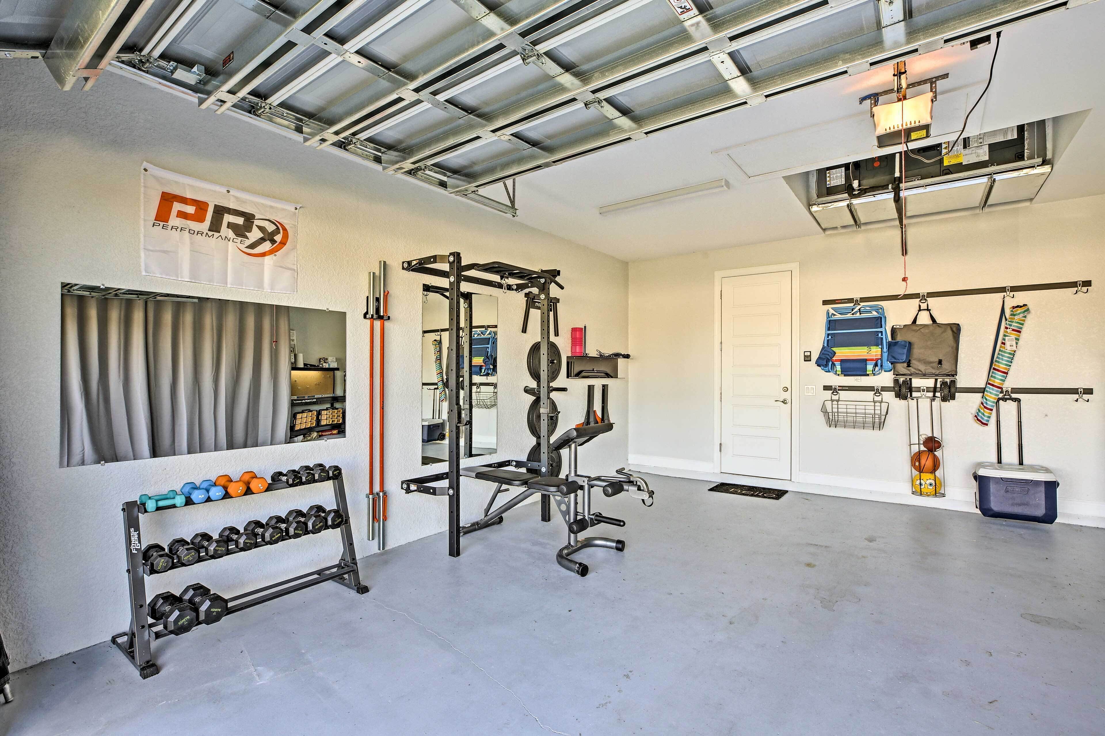Un gimnasio con una estructura para sentadillas, mancuernas y discos de pesas.