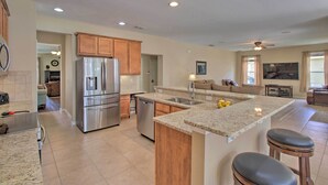 A modern kitchen with granite countertops, stainless steel appliances, and wooden cabinets. - Outdoor Oasis w/ Pool: Davenport Resort Escape! (Davenport)