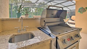 An outdoor kitchen with a stainless steel grill, a sink, and potted plants. - Outdoor Oasis w/ Pool: Davenport Resort Escape! (Davenport)