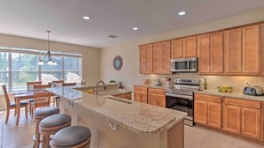 A kitchen with wooden cabinets, a granite countertop, a built-in microwave, and a sink. - Outdoor Oasis w/ Pool: Davenport Resort Escape! (Davenport)