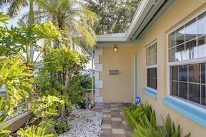 A building with a covered patio area, a stone pathway, and various plants. - Waterfront Oasis! Heated Pool, 2 Docks & Boat Lift (Palmetto)