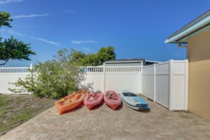 A paved patio with kayaks and a paddleboard. - Waterfront Oasis! Heated Pool, 2 Docks & Boat Lift (Palmetto)