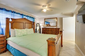 A bedroom with a wooden bed, a nightstand, a dresser, a mirror, and a ceiling fan. - Waterfront Oasis! Heated Pool, 2 Docks & Boat Lift (Palmetto)