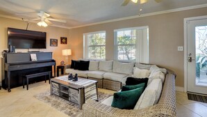 A living room with a piano, a sofa, a coffee table, and a ceiling fan. - Waterfront Oasis! Heated Pool, 2 Docks & Boat Lift (Palmetto)