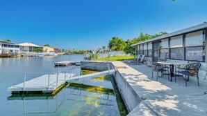 Une propriété située au bord de l’eau, dotée d’un quai, d’une piscine et d’un espace salon extérieur.