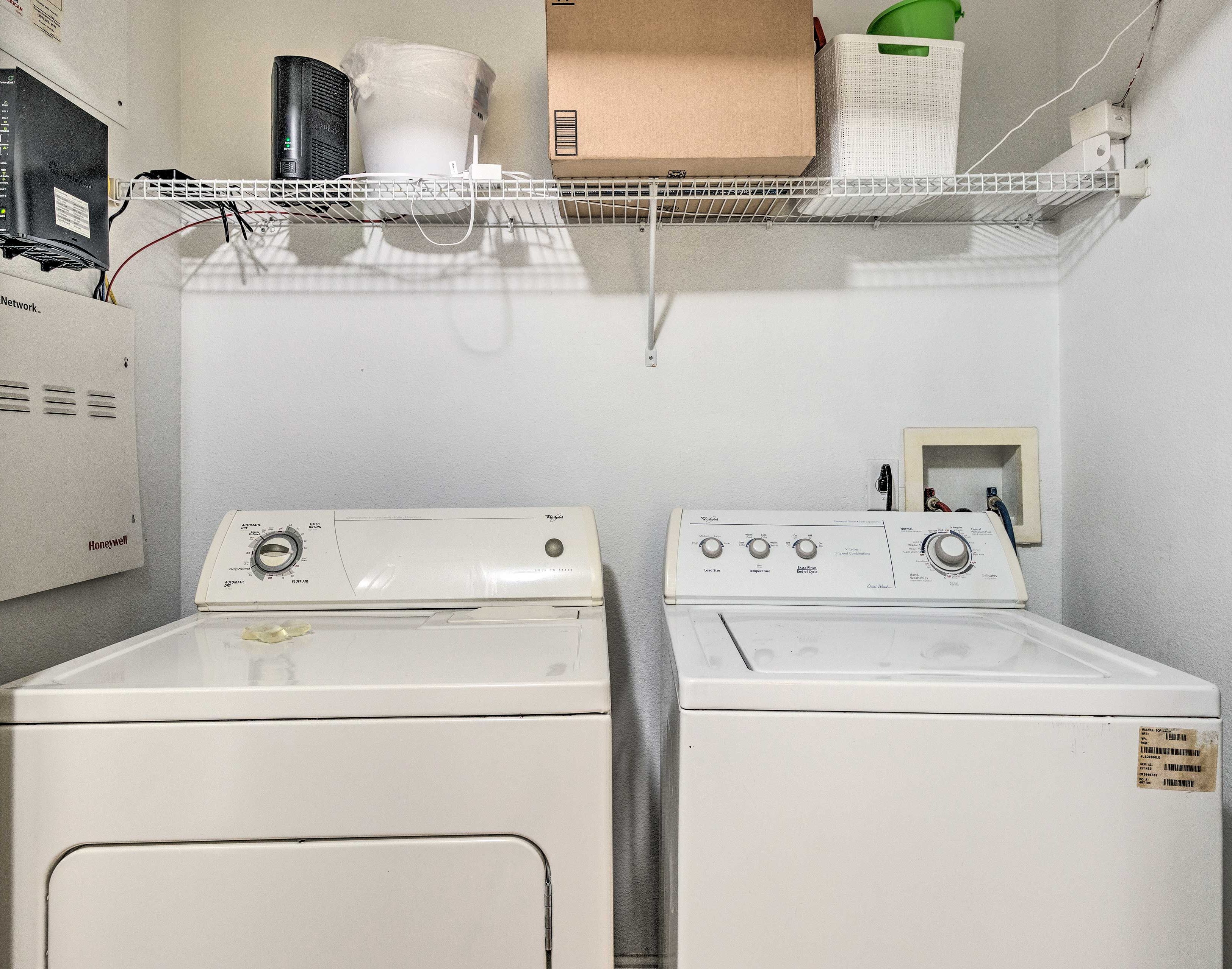 A laundry area with two front-loading washing machines and a dryer.