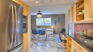 A modern kitchen with stainless steel appliances, wooden cabinets, and a marble floor. - Wilton Manors Home w/ Pool ~ 4 Mi to Beach! (Wilton Manors)