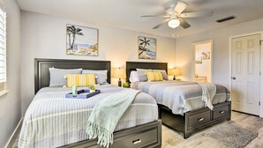A bedroom with two beds, a ceiling fan, and artwork on the walls. - 'tipsy Turtle' Condo w/ Patio & Harbor Access (Destin)