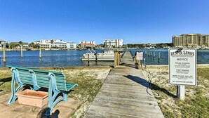 A wooden pier leading to a dock with a bench and a sign for Destin Sands. - 'tipsy Turtle' Condo w/ Patio & Harbor Access (Destin)