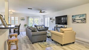 A spacious living room with a grey sofa, beige sofa, and a dining area with a table and chairs. - 'tipsy Turtle' Condo w/ Patio & Harbor Access (Destin)