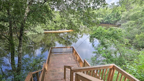 A wooden bridge leading to a dock over a calm lake surrounded by dense greenery. - Waterfront Sopchoppy Hideaway w/ 2 Kayaks! (Sopchoppy)