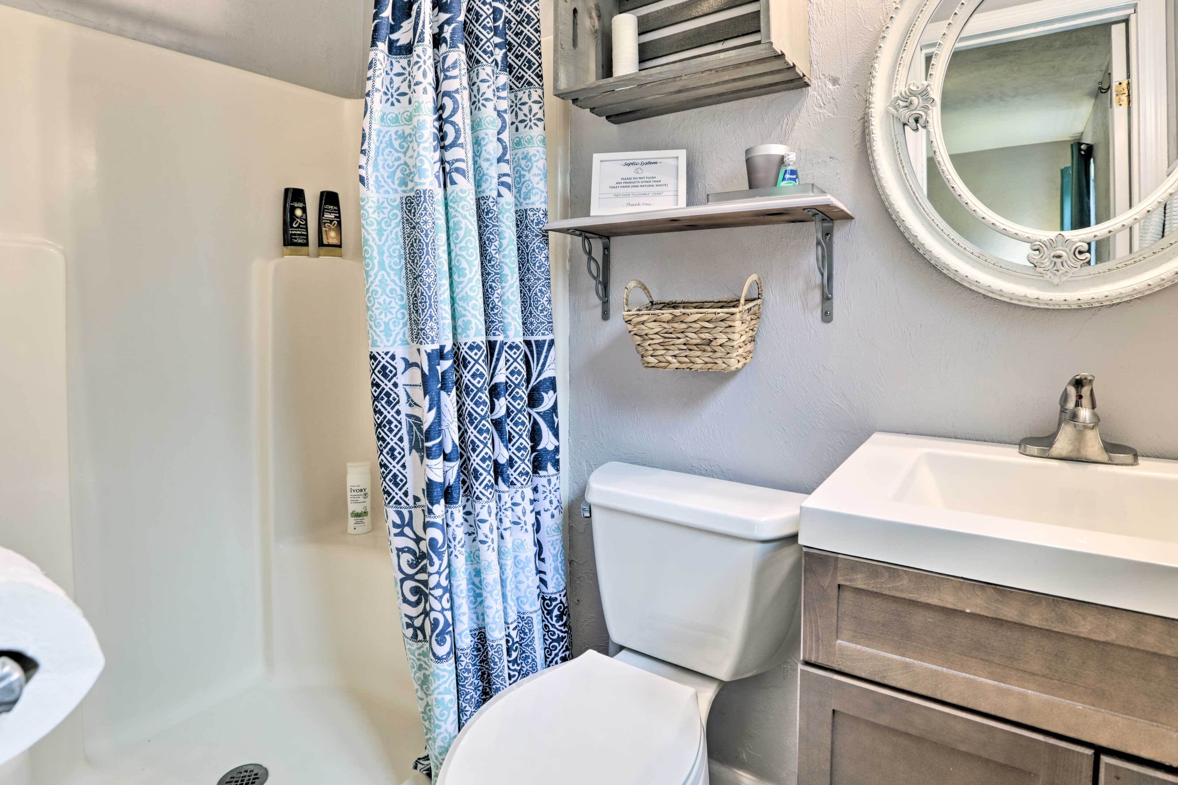 A bathroom with a shower, toilet, and sink.
