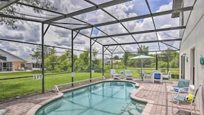 A covered swimming pool with a patio area, lounge chairs, and a 3 FT. sign. - Disney Villa w/ Game Room & Pool - 10 Mi to Parks! (Clermont)