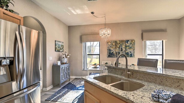 A modern kitchen with stainless steel appliances, granite countertops, and a large island with a sink. - Disney Villa w/ Game Room & Pool - 10 Mi to Parks! (Clermont)