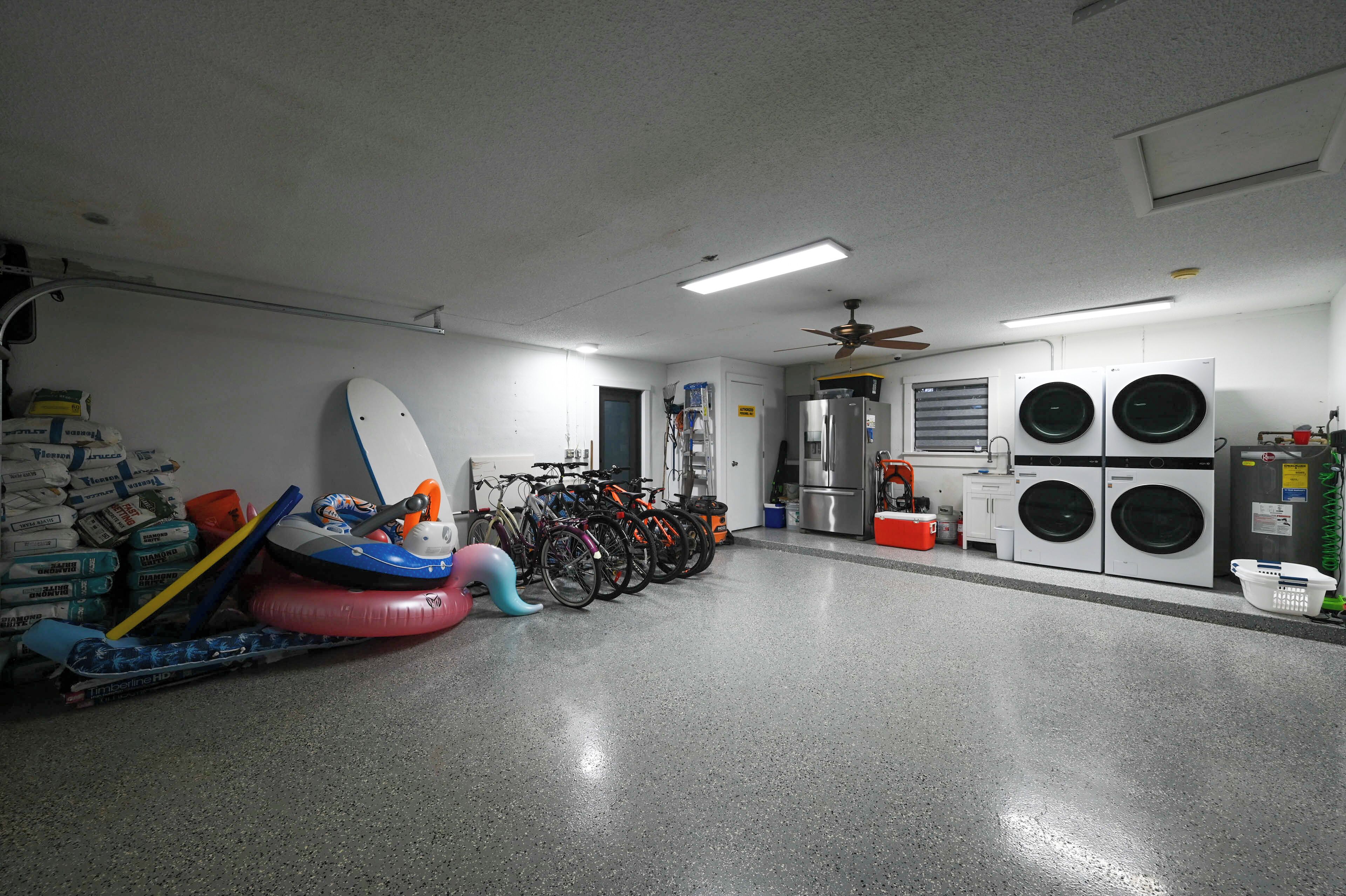A laundry room with washing machines, a ceiling fan, and bicycles.
