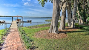 A lakeside walkway with a gazebo and dock extending into the water.
