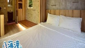 A bedroom with a large bed, wooden headboard, and a built-in wardrobe. - Bahile (Liuqiu)