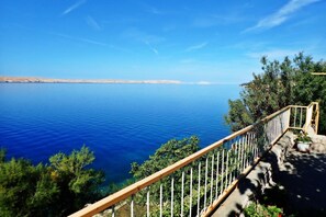 A balcony with a clear view of a calm sea and distant land. - 2-BR Seaview Apartment in Barić Draga (Barić Draga)