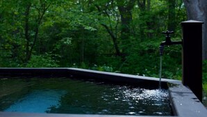 A water feature with a faucet in a forested area. - HOTEL BOTH - Hostel (Shari)