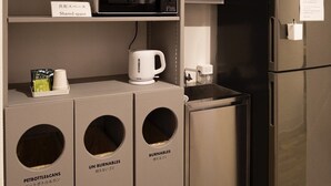 A kitchenette with a microwave, a coffee maker, and labeled bins for pet bottles and cans. - HOTEL BOTH - Hostel (Shari)