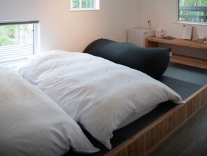 A bed with white bedding, a dark headboard, and a wooden bedside table with a kettle and a cup. - HOTEL BOTH - Hostel (Shari)