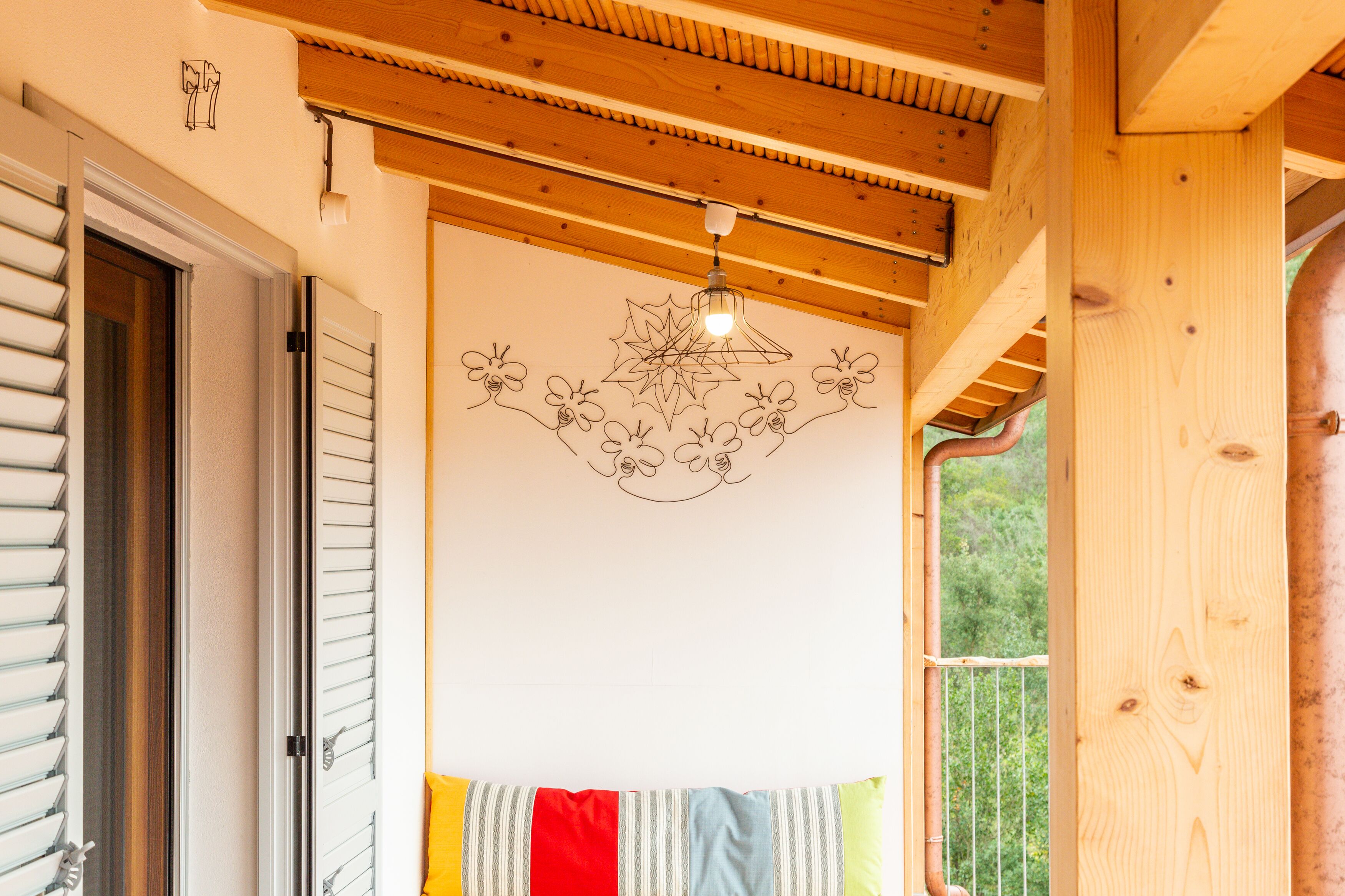 Techo de madera con una lámpara colgante y una pared con diseño floral.