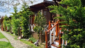 Une rangée de cabanes en bois, avec des allées pavées de pierres et une végétation luxuriante.