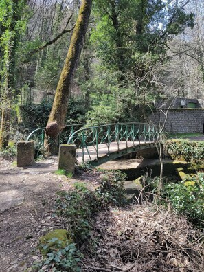 A stone bridge with green metal railings in a wooded area. - Gîte le Milan, en Plein Cœur de la Magnifique Petite Ville de Florac (Florac-Trois-Rivières)