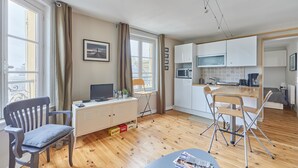 Un apartamento moderno con comedor, cocina y un espacio de trabajo con escritorio y silla.