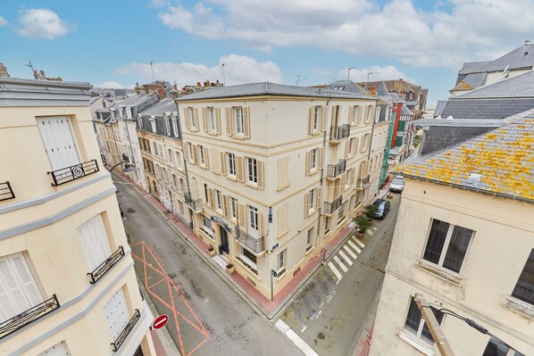 A multi-story building with a classic architectural style, featuring balconies and a central entrance.