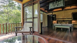 Une pièce spacieuse avec une grande fenêtre, un banc en bois et une table en verre.