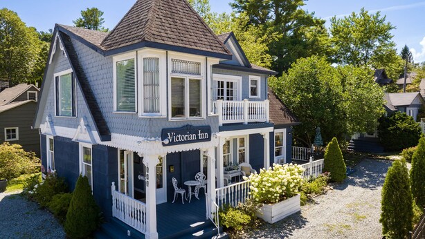 A Victorian-style inn with a two-story structure, a balcony, and a gravel driveway. - The Victorian Inn Blowing Rock (Blowing Rock)