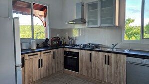 Eine moderne Küche mit Holzschränken, einem eingebauten Backofen und einem Geschirrspüler.