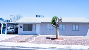 A single-story house with a garage, a driveway, and a small tree in the front yard. - Beautiful and cozy house in Las Vegas (Las Vegas)