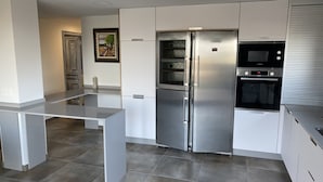 A modern kitchen with a stainless steel refrigerator, built-in oven, and microwave. - Cozy Nest w/private garden next to vineyards and great wineries (Cambados)