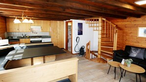 Un intérieur en bois comprenant une cuisine, un coin repas et un espace de vie.