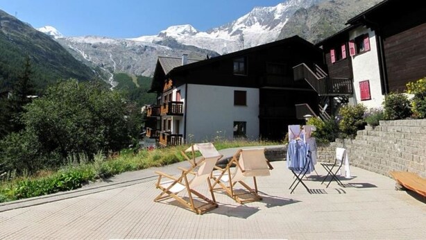 A mountain lodge with a view of snow-capped peaks.