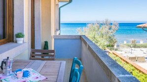 A balcony with a view of the sea, a table with chairs, and a small potted plant. - Marequì by Interhome (San Vincenzo)