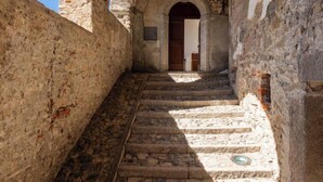 Una estrecha escalera de piedra que conduce a un arco de entrada en un edificio histórico.