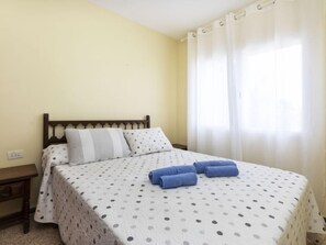 A single bed with a polka dot bedspread, two pillows, and rolled towels on the bed. - Las Terrazas de Atalayas by Interhome (Peñiscola)